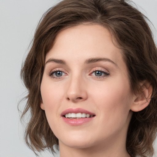 Joyful white young-adult female with medium  brown hair and green eyes