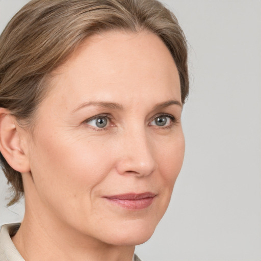 Joyful white adult female with medium  brown hair and grey eyes