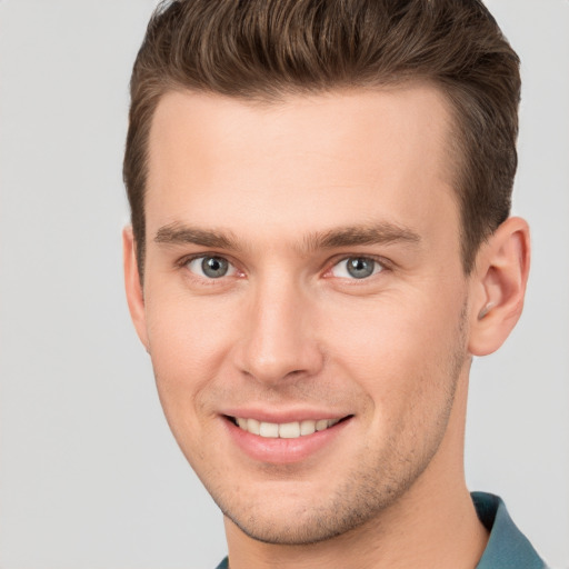 Joyful white young-adult male with short  brown hair and grey eyes