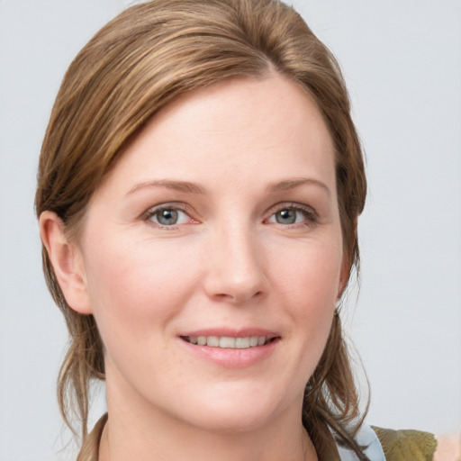 Joyful white young-adult female with medium  brown hair and grey eyes