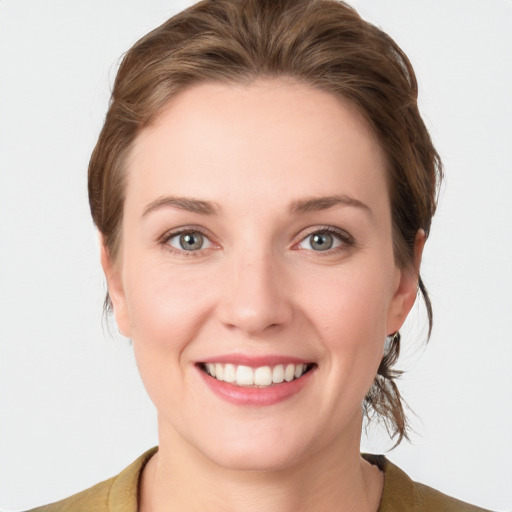 Joyful white young-adult female with medium  brown hair and blue eyes