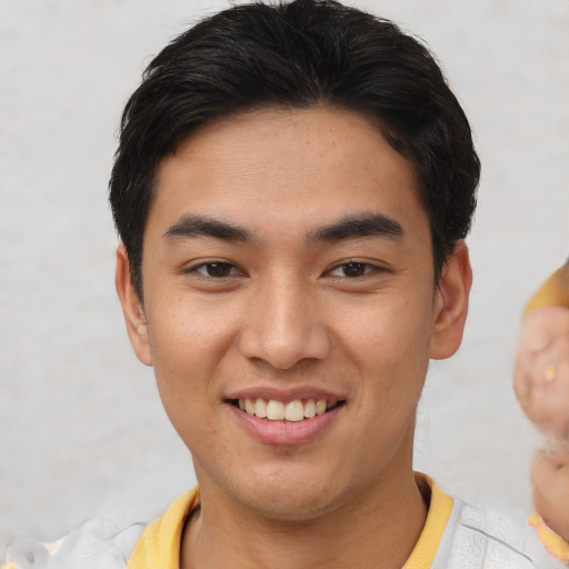 Joyful asian young-adult male with short  brown hair and brown eyes