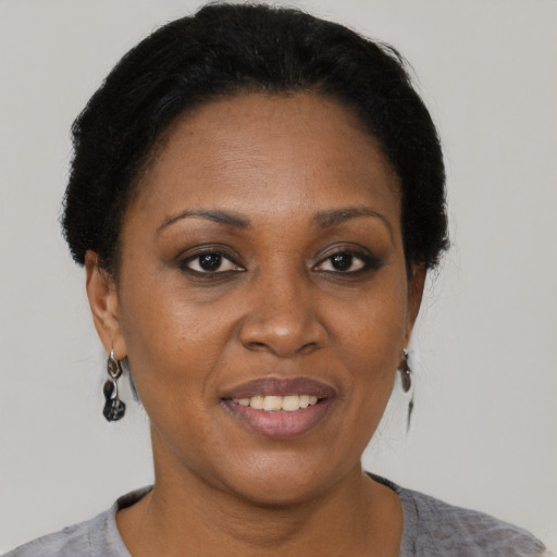 Joyful black adult female with short  brown hair and brown eyes