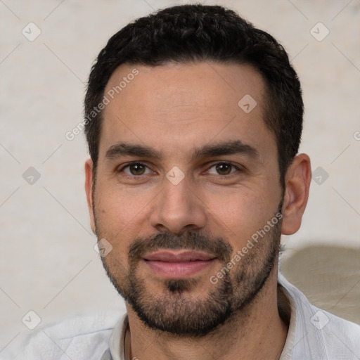 Joyful white young-adult male with short  black hair and brown eyes