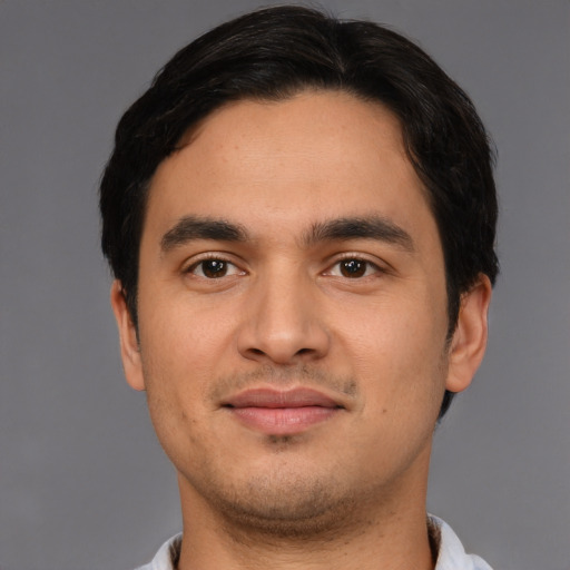 Joyful latino young-adult male with short  brown hair and brown eyes