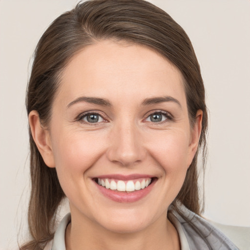 Joyful white young-adult female with medium  brown hair and grey eyes