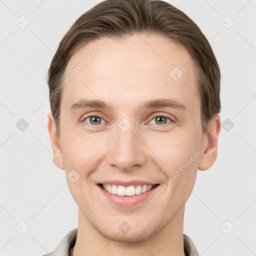 Joyful white young-adult male with short  brown hair and grey eyes