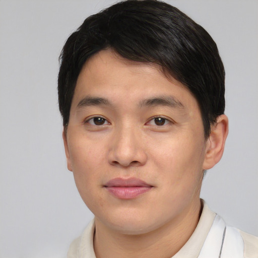 Joyful asian young-adult male with short  brown hair and brown eyes