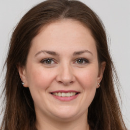 Joyful white young-adult female with long  brown hair and brown eyes