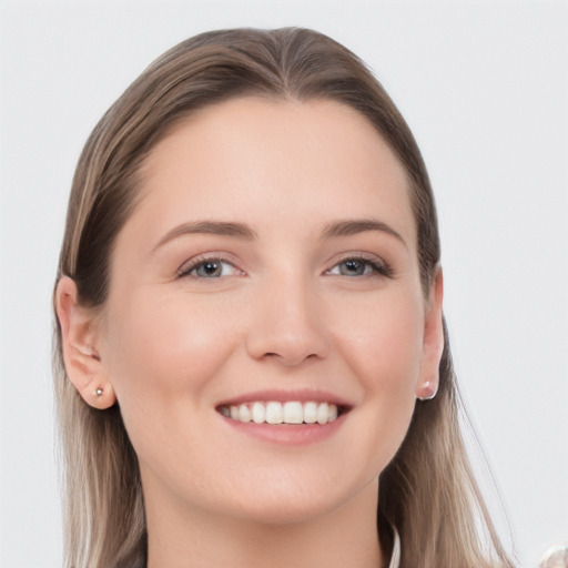 Joyful white young-adult female with long  brown hair and grey eyes