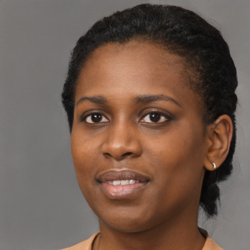 Joyful black young-adult female with short  black hair and brown eyes
