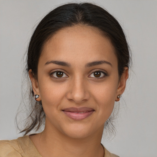 Joyful latino young-adult female with medium  brown hair and brown eyes