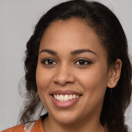 Joyful latino young-adult female with long  brown hair and brown eyes
