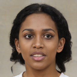 Joyful black young-adult female with medium  brown hair and brown eyes