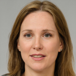 Joyful white adult female with long  brown hair and green eyes