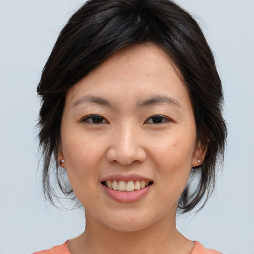 Joyful asian young-adult female with medium  brown hair and brown eyes