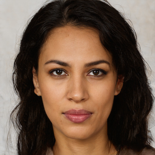 Joyful latino young-adult female with long  brown hair and brown eyes