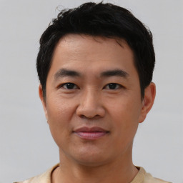 Joyful asian young-adult male with short  black hair and brown eyes