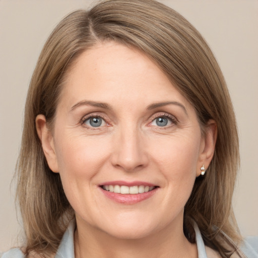 Joyful white adult female with medium  brown hair and grey eyes