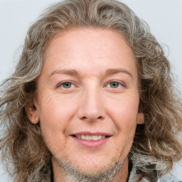 Joyful white adult female with medium  brown hair and blue eyes