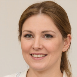 Joyful white adult female with medium  brown hair and grey eyes