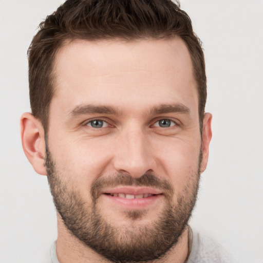 Joyful white young-adult male with short  brown hair and grey eyes