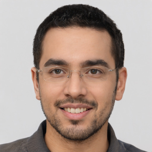 Joyful latino young-adult male with short  black hair and brown eyes