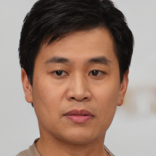 Joyful asian young-adult male with short  brown hair and brown eyes