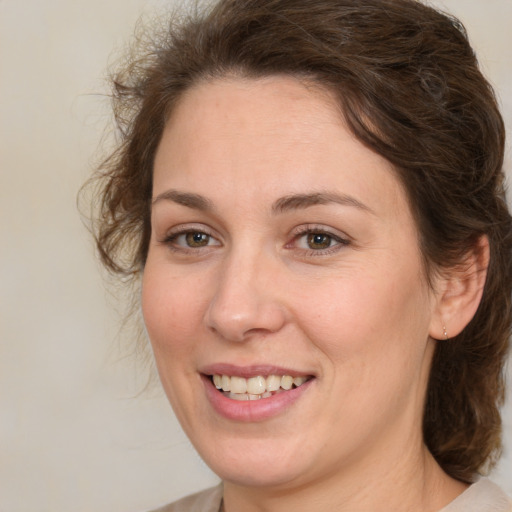 Joyful white young-adult female with medium  brown hair and green eyes