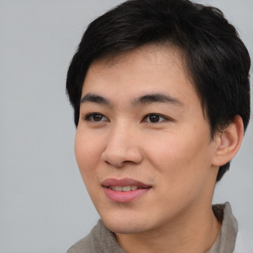 Joyful asian young-adult male with short  black hair and brown eyes