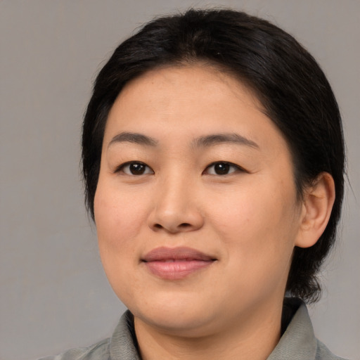 Joyful asian young-adult female with medium  black hair and brown eyes