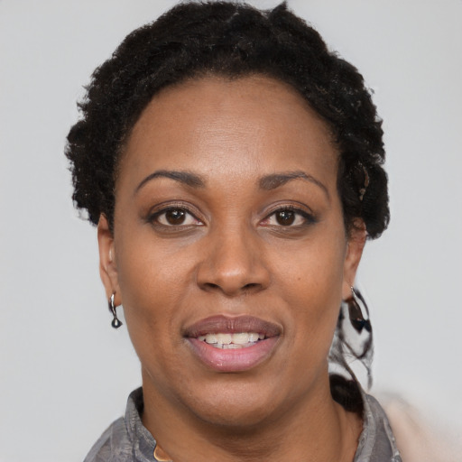 Joyful black adult female with short  brown hair and brown eyes