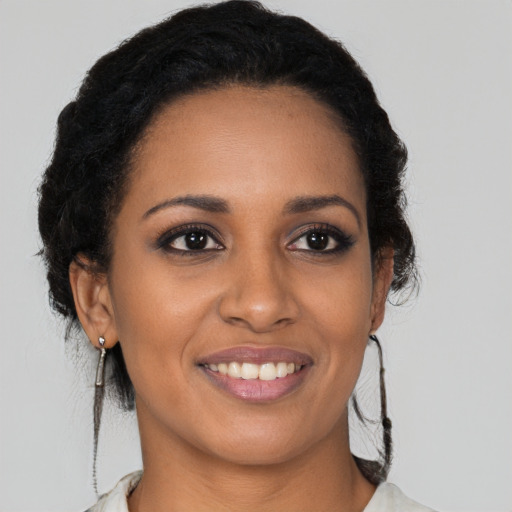 Joyful black young-adult female with long  brown hair and brown eyes