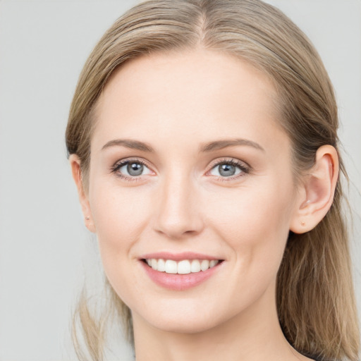 Joyful white young-adult female with long  brown hair and blue eyes