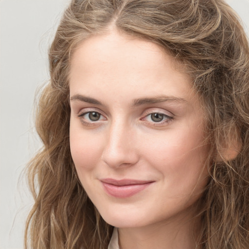 Joyful white young-adult female with long  brown hair and green eyes