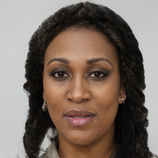 Joyful black young-adult female with long  black hair and brown eyes