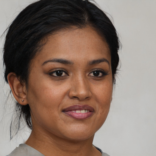 Joyful black young-adult female with medium  brown hair and brown eyes