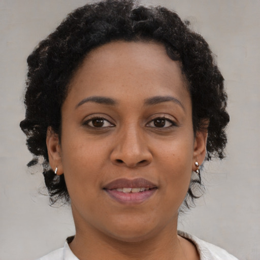 Joyful black young-adult female with short  brown hair and brown eyes