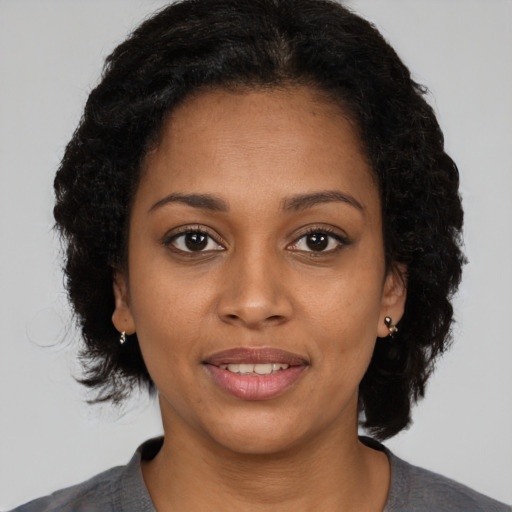 Joyful black young-adult female with medium  black hair and brown eyes