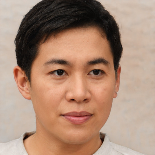 Joyful asian young-adult male with short  brown hair and brown eyes