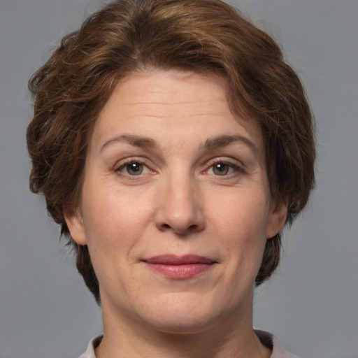 Joyful white adult female with medium  brown hair and grey eyes