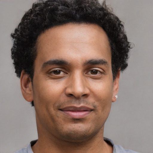 Joyful latino young-adult male with short  brown hair and brown eyes