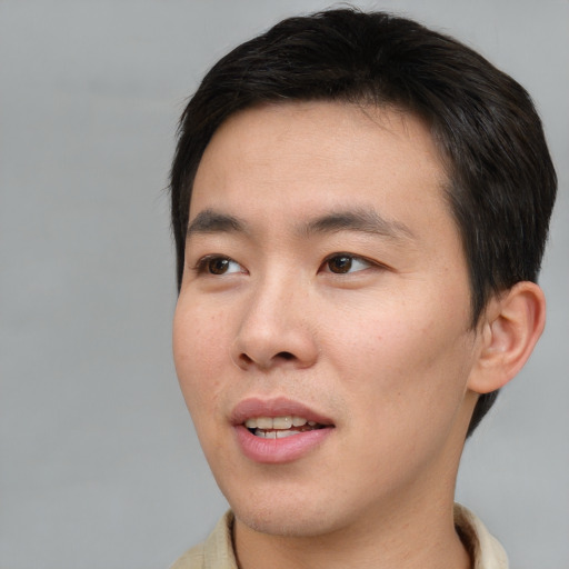 Joyful asian young-adult male with short  brown hair and brown eyes