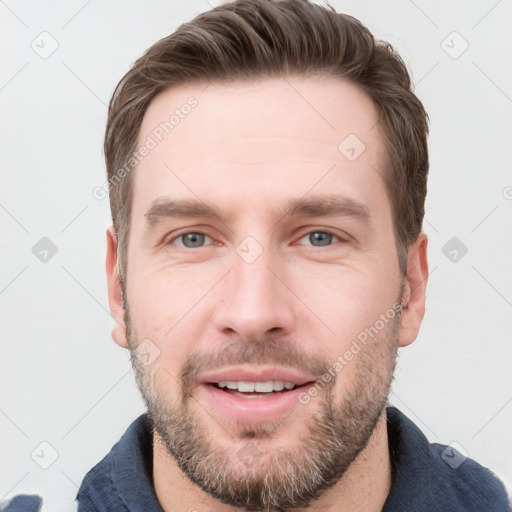 Joyful white young-adult male with short  brown hair and grey eyes