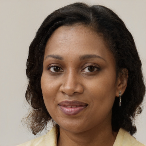 Joyful black adult female with medium  brown hair and brown eyes