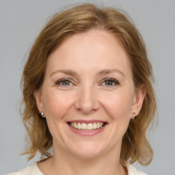 Joyful white adult female with medium  brown hair and grey eyes