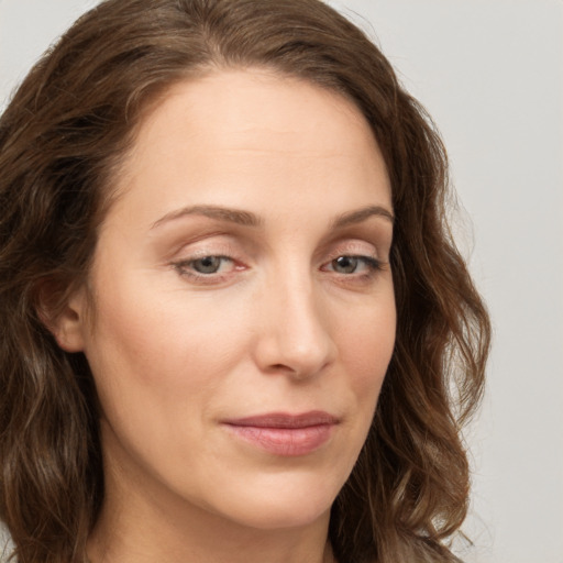 Joyful white young-adult female with long  brown hair and blue eyes