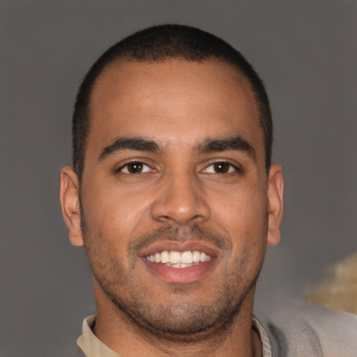 Joyful latino young-adult male with short  brown hair and brown eyes