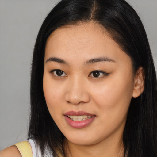 Joyful asian young-adult female with long  brown hair and brown eyes