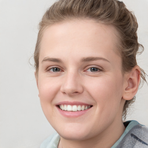 Joyful white young-adult female with medium  brown hair and blue eyes